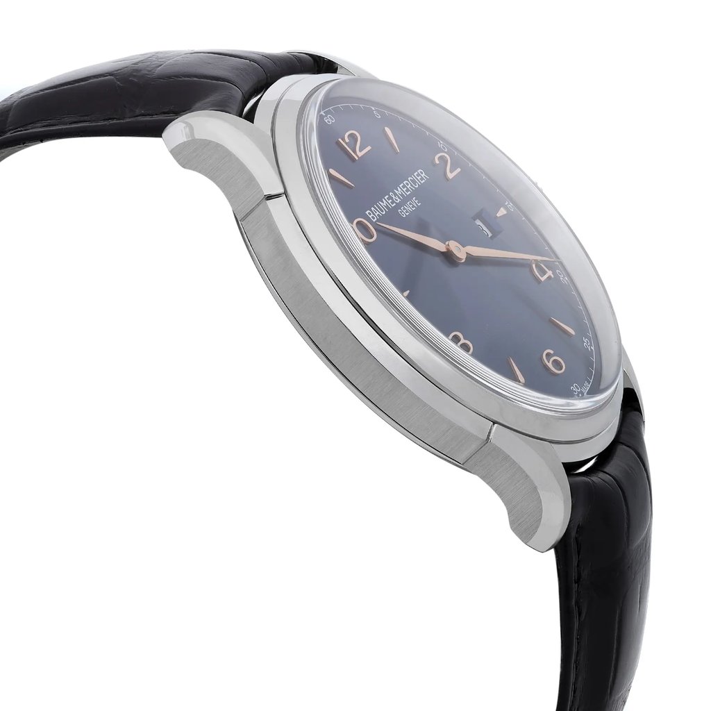 An image of a Wristwatch by Baume & Mercier. This Display Model item is designed for Men, featuring a Casual style. It has a Quartz movement and an Analog display with a Blue dial color. The indices include Arabic Numerals,Stick Indexes. The band is made of Leather and the case is made of Stainless Steel. The watch has a Round shape with a case size of 45 mm and a case thickness of 11 mm.