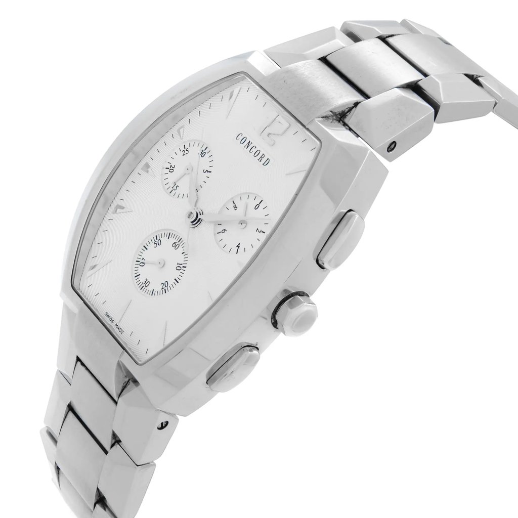 An image of a pre-owned wristwatch captured from a side profile view, displaying the crown prominently. The watch features a metallic bracelet and a white dial with three sub-dials. The angle highlights the sleek design and the polished finish of the case and band, with the watch slightly tilted to the right. The photo is taken at a close distance, emphasizing the details of the watch's craftsmanship.