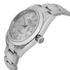 An image of a pre-owned wristwatch shown from a side profile view, highlighting the crown. The watch is angled slightly upward, showcasing its sleek metal band and silver dial. The distance is close enough to capture fine details such as the brand logo on the crown and the text on the dial.