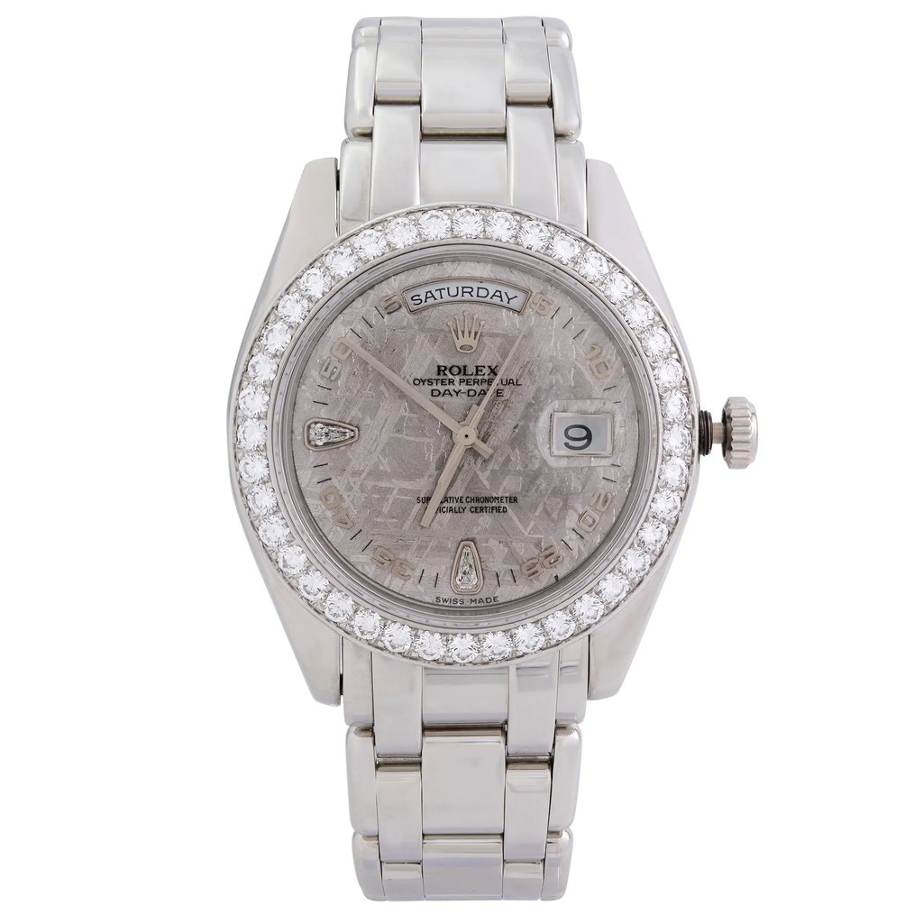 An image of a pre-owned wristwatch taken from a full frontal view. The watch features a silver metal bracelet and a round face encircled by a diamond-studded bezel. The dial displays the day and date functions, with the day at the top and the date at the 3 o'clock position. The watch is positioned upright, centered in the image, capturing its details clearly from a direct and close distance.