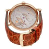 An image of a pre-owned Breguet men's wristwatch, showcased from the back view with a closed clasp. The watch is positioned at a slight angle that allows visibility of the exhibition caseback, revealing the intricate movement and the brand's signature engravings. The case material is yellow gold and the round shape of the watch is evident. Attached is a brown leather band with a texture resembling crocodile skin, secured with a yellow gold buckle that matches the case. The distance is close enough to capture the details of the watch's mechanics and the texture of the leather band, providing a clear view of the watch's craftsmanship.