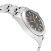 An image of a pre-owned men's Rolex wristwatch in a side profile view opposite of the crown. The watch features a round stainless steel case and band. It has a black dial with white markers and an orange seconds hand, visible at a close distance and angled to display the side curvature of the case and band. The watch shows light signs of wear or scratches.