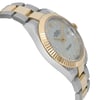 An image of a pre-owned wristwatch viewed from the side profile, opposite the crown. The watch features a two-tone metal band with gold and silver links. The angle highlights the fluted gold bezel and a light-colored dial adorned with diamond hour markers. The watch face is partially visible, showcasing the brand name and date display. The shot is taken at a close distance, emphasizing the watch's luxurious details.