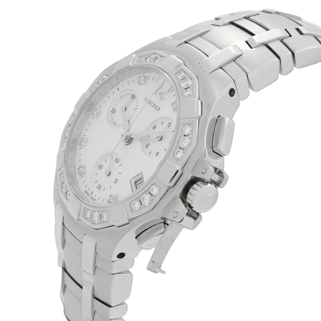 An image of a pre-owned wristwatch shown from a side profile view. The focus is on the crown, which is prominently displayed. The watch features a metallic bracelet and a round face with a decorative bezel. The angle captures the detailing on the side and the texture of the wristband, with the watch positioned at a close distance.