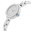 An image of a wristwatch viewed from the side profile, showcasing the crown prominently. The watch is positioned at an angle that highlights its sleek design and metallic finish. The distance is close enough to display intricate details such as the polished links of the bracelet and the minimalist dial with hour markers. The crown features a blue accent, adding a touch of color to the otherwise silver-toned watch. The watch is in display model condition.