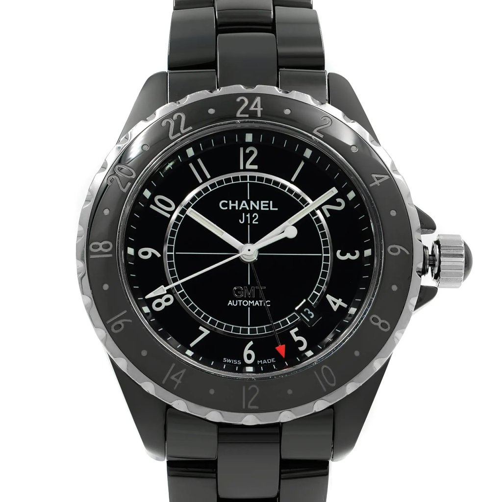 An image of a pre-owned wristwatch taken from a front close-up angle, highlighting the watch face. The watch features a black dial with white numerals and hands, and a silver bezel with 24-hour markings. The brand "Chanel J12" is displayed on the dial, along with "GMT" and "Automatic." The watch has a black ceramic bracelet and a prominent crown on the right side.
