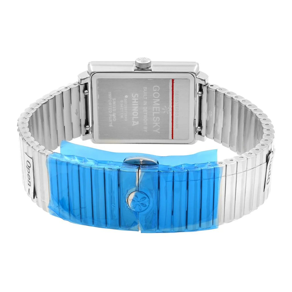 An image of a wristwatch viewed from the back, showcasing a close-up of the clasp. The watch is unworn, with a rectangular case and a metallic band partially covered in protective blue film. The clasp is prominently displayed in the foreground, and the brand name is visible on the back of the watch case. The angle captures the watch from above and slightly to the side, emphasizing its pristine condition.