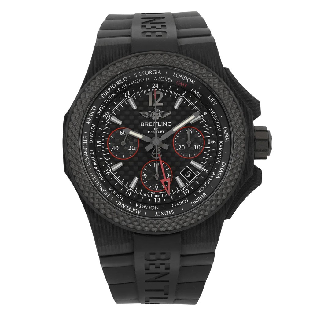An image of a wristwatch shown from a full frontal view. The watch is positioned upright, displaying its intricate black dial with white and red accents. The bezel features city names for various time zones. The rubber strap is visible, and the watch is in display model condition. The image is taken at a close distance, emphasizing the watch's detailed craftsmanship.