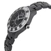 An image of a wristwatch displayed in a side profile view, showcasing the crown prominently. The watch features a dark, glossy bracelet and a bezel adorned with alternating segments of black and diamond-like stones. The watch face is black with silver-tone markers and hands, and the brand name is visible. The angle emphasizes the watch's sleek design and luxurious detailing, capturing it from a close distance.