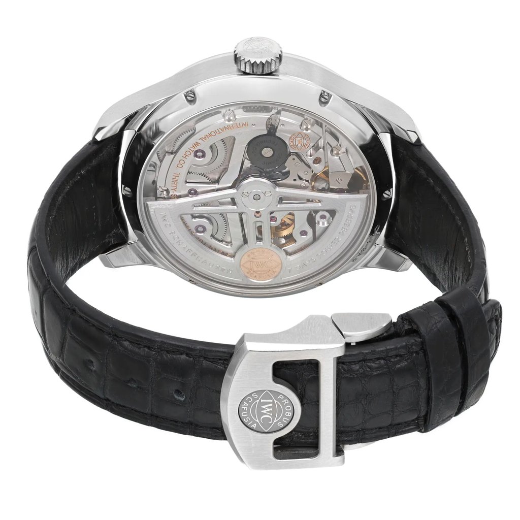 An image of a pre-owned wristwatch shown from the back view with an open clasp. The angle highlights the intricate mechanical details of the watch's movement. The watch features a black leather strap with a clasp that displays a circular emblem. The photograph is taken at a close distance, capturing the polished metal case and detailed craftsmanship.