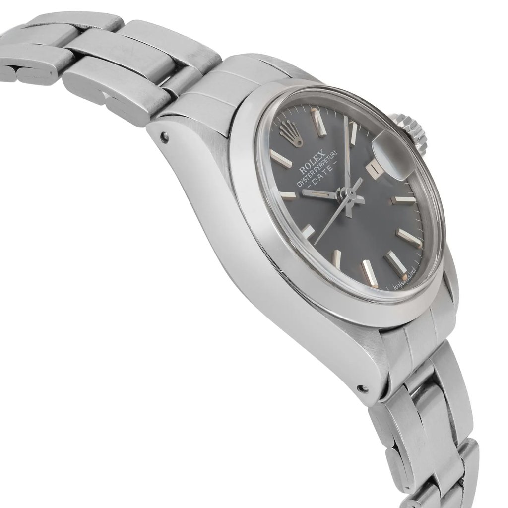 An image of a pre-owned wristwatch shown from a side profile view, opposite the crown. The angle highlights the sleek design of the watch case and metallic bracelet. The photograph is taken at a close distance, emphasizing the watch's details and craftsmanship.