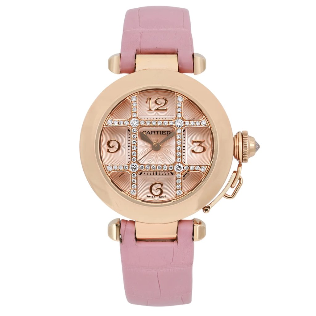 An image of a pre-owned Cartier Pasha De 32mm women's rose gold grille silver dial wristwatch taken from a front-facing angle. The watch features a round rose gold case with a prominent crown on the right side. The dial includes a date indicator and is adorned with sparkling embellishments around the numeral markers. The watch has a pink leather strap, and the image is captured at a close-up distance to highlight the intricate details.