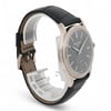 An image of a pre-owned men's Patek Philippe wristwatch positioned at a slight angle, showcasing the side and part of the face. The watch has a sleek black leather strap and a polished metal case. The angle highlights the watch's elegant design and craftsmanship, with the focus on the watch face and its detailed markers. The distance is close, providing a clear view of the watch's features.