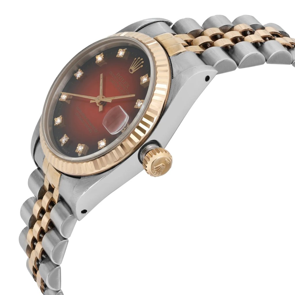 An image of a pre-owned wristwatch shown from a side profile view, highlighting the crown. The watch features a two-tone design with a gold fluted bezel and a stainless steel and gold bracelet. The dial is adorned with diamond hour markers, and the brand logo is visible at the 12 o'clock position. The image is taken at a close angle, emphasizing the watch's luxurious details.