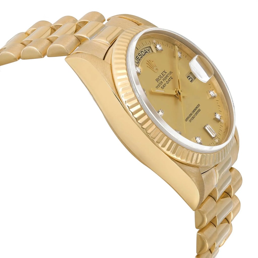 An image of a pre-owned Rolex men's wristwatch captured from a side profile opposite the crown. The photograph is a close-up shot, highlighting the watch's luxury style. It features a round gold sunburst dial, gold bezel, and yellow gold band and case. The dial includes a day/date function and luminous hands, presented at a slight angle to emphasize the watch's thickness and the curvature of the band. The watch shows light signs of wear due to age.