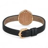 An image of a pre-owned women's Cartier wristwatch, viewed from the back at a slight angle. The focus is on the circular gold case, with engraved text visible, and the black leather strap. The watch is positioned centrally, with the strap extending outward, and the gold buckle is prominently displayed in the foreground.