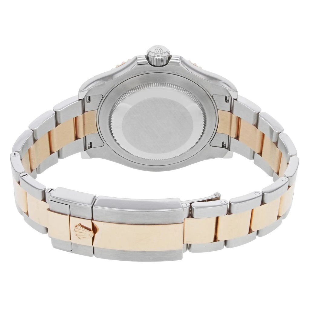 An image of a pre-owned wristwatch taken from the back view, showing the closed clasp. The watch features a two-tone metal band with silver and gold elements. The angle captures the watch's back case prominently, with the crown visible at the top. The image is taken at a close distance, highlighting the details of the clasp and the bracelet links.