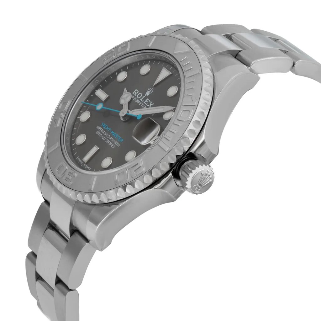 An image of a pre-owned wristwatch captured from a side profile view. The angle highlights the crown prominently on the right side of the watch case. The watch features a metallic bracelet and a detailed bezel with visible engravings. The face of the watch is partially visible, showing its design and markers. The photograph is taken at a close distance, showcasing the watch's craftsmanship and condition.