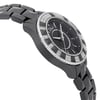 An image of a wristwatch captured from a side profile view, showing the opposite side of the crown. The watch features a sleek black bracelet and a distinctive bezel adorned with alternating black and diamond-like segments. The face of the watch is dark, with a minimalistic design, set at an angle that highlights its elegant contours. The photograph is taken at a close distance, emphasizing the intricate details of the watch's design.
