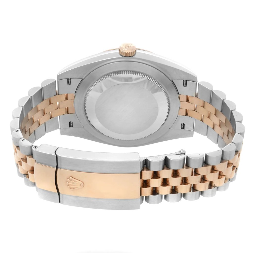 An image of a pre-owned Rolex men's wristwatch in good condition, showing light signs of wear or scratches. The photo presents a close-up back view of the watch, focusing on the screwback case back made of stainless steel and the fold-over clasp. The round-shaped case is attached to a two-tone band combining rose gold and stainless steel links. The clasp is centered and detailed with the Rolex crown logo. The watch is positioned horizontally with the clasp closed and the band slightly tapering off towards the top and bottom edges of the frame, suggesting a natural wrist-like curve.