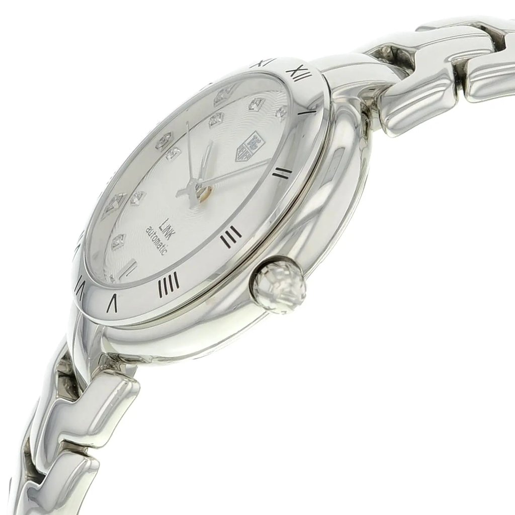 An image of a pre-owned TAG Heuer wristwatch viewed from the side profile, highlighting the crown. The watch features a round stainless steel case and band, with a silver guilloche-patterned dial and a gray bezel. The elegant women's dress/formal watch includes a date indicator. The image is taken at close range, showcasing the intricate details and craftsmanship.