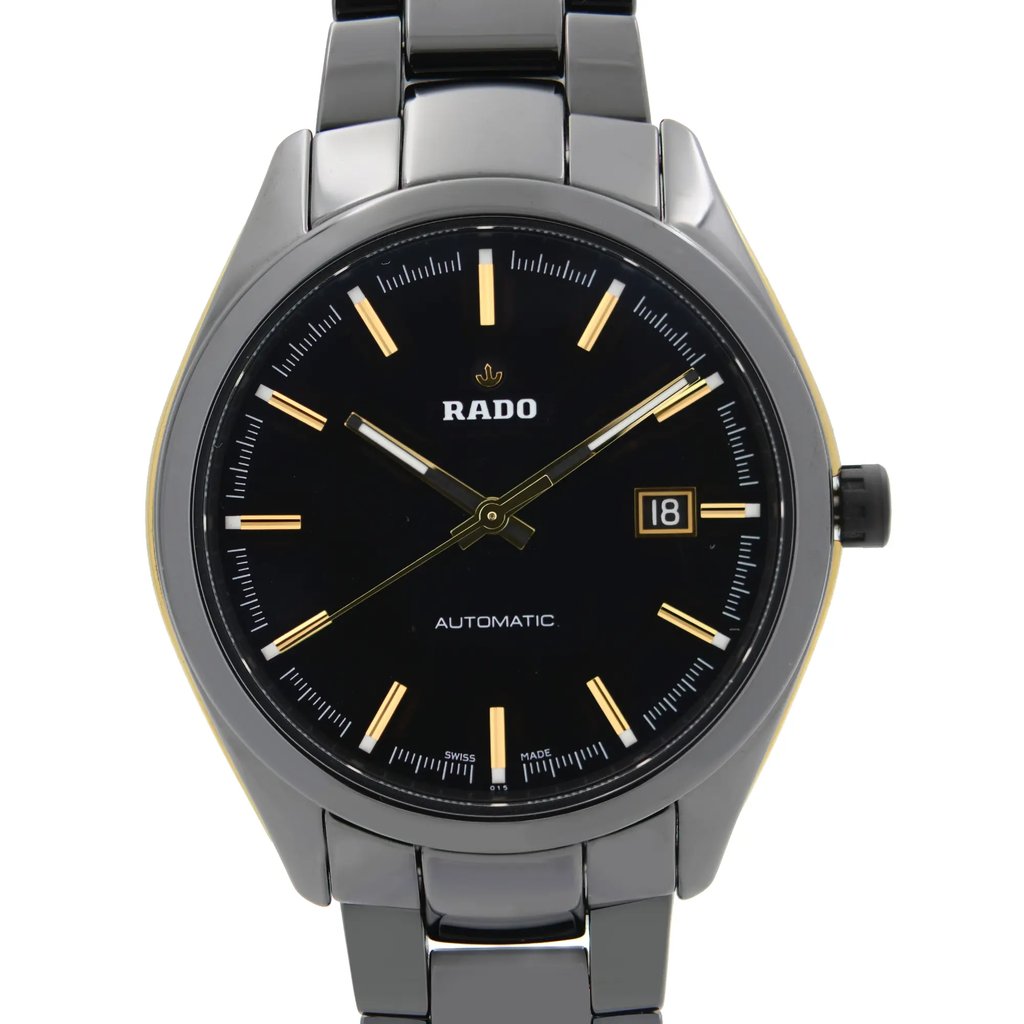 An image of a pre-owned wristwatch captured in a front close-up shot, highlighting the watch face. The watch features a black dial with gold hour markers and hands. The date function is visible at the 3 o'clock position. The brand name is displayed on the dial, and the watch has a sleek metal bracelet and case.