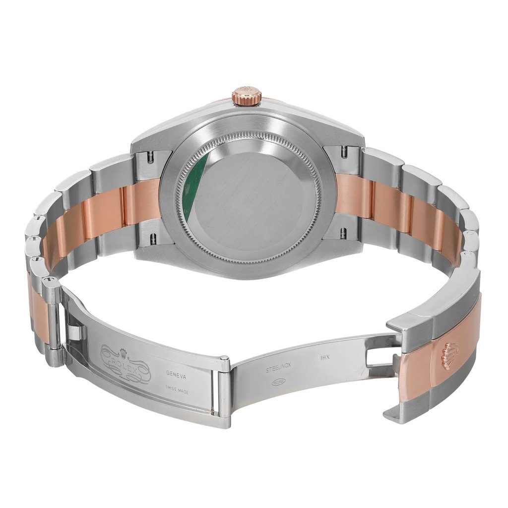 An image of a pre-owned Rolex wristwatch for men, viewed from the back with an open clasp. The watch is composed of stainless steel and rose gold materials and features a round shape with a screwback caseback showing a sticker. The fold-over clasp is partially unfolded, and the band exhibits minor signs of wear or scratches. The watch is positioned centrally with the caseback facing up, and the image is taken from a medium distance, capturing the entire back view of the watch.