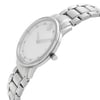An image of a pre-owned wristwatch captured from a side profile view. The watch features a sleek design with a visible crown on the right side. The angle showcases the metallic bracelet and the minimalist watch face, emphasizing its clean and elegant aesthetic. The image is taken from a close distance, highlighting the details of the watch's construction.
