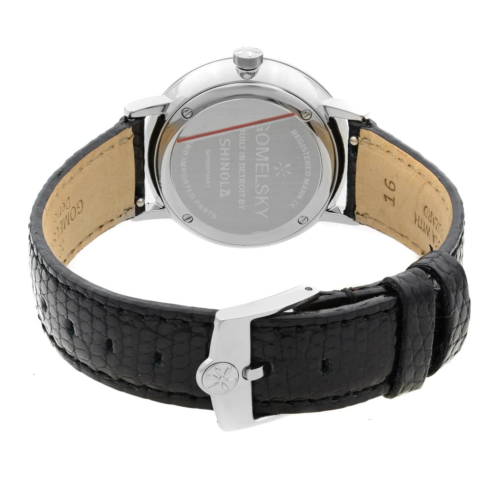 An image of a wristwatch viewed from the back, showcasing the close clasp. The watch is positioned upright with the focus on the smooth metallic back, engraved with brand details. The black leather strap is visible, exhibiting its texture and unworn condition. The angle provides a clear view of the watch’s construction and clasp mechanism, captured at a close distance.