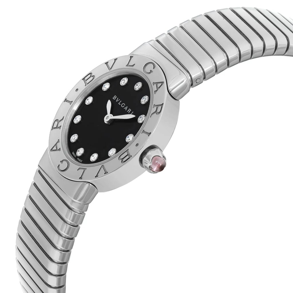 An image of a Bvlgari luxury wristwatch for women. It is a display model with a side profile view emphasizing the crown. The round watch face has a black dial with a diamond pattern, accented by diamond hour markers and the Bvlgari brand name engraved around the bezel, which is gray. The stainless steel band has a continuous, ribbed design, and the image is taken from a close distance, focusing on the watch from the side, allowing a clear view of the watch's design and the crown's position on the case.
