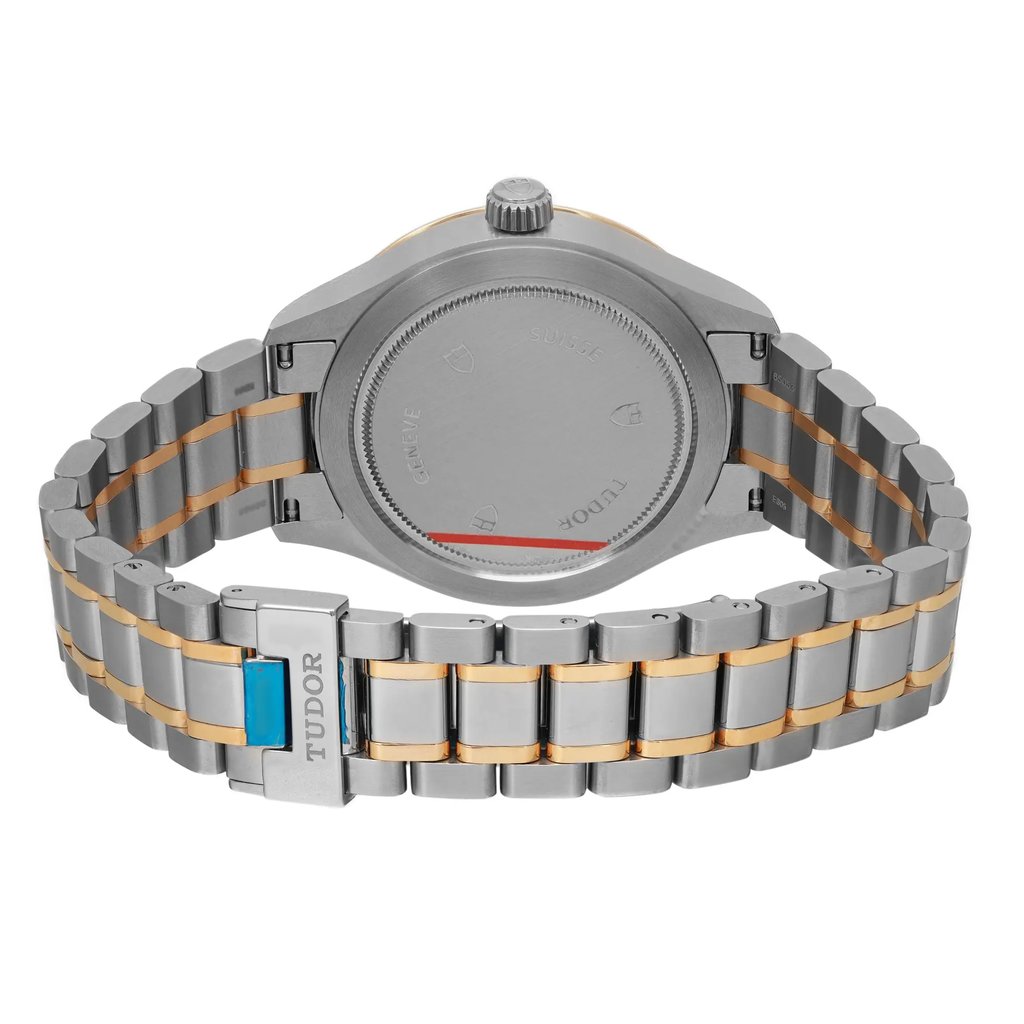 An image of a wristwatch taken from the back view, showcasing its closed clasp. The watch features a metallic band with alternating silver and gold links. The focus is on the unworn condition of the watch, highlighting the brand name on the clasp. The angle captures the full length of the band and the caseback, with the image taken at a close distance to emphasize details.