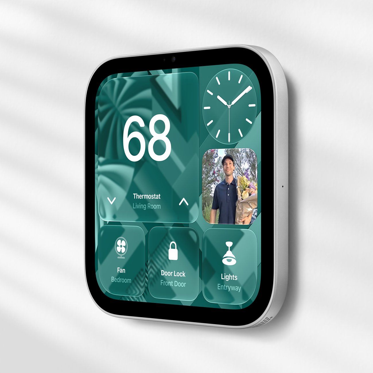 Apple HomeView als Wandvariante, schräg von der Seite: auf dem Display Thermostat, Uhr, ein Kamerabild und Kacheln für Ventilator, Türschloss und Licht