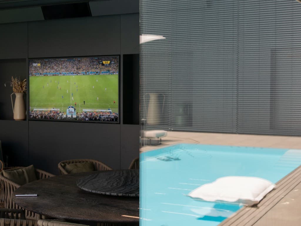 AVITECT Referenzprojekt: fest eingebautes Outdoor-Display an einer Pool-Terrasse bei Tageslicht