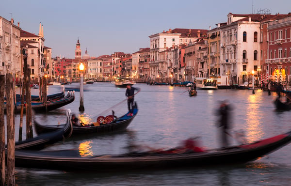 Venice Grand Canal at golden hour — historic palazzos lining the waterway with gondolas and water taxis
