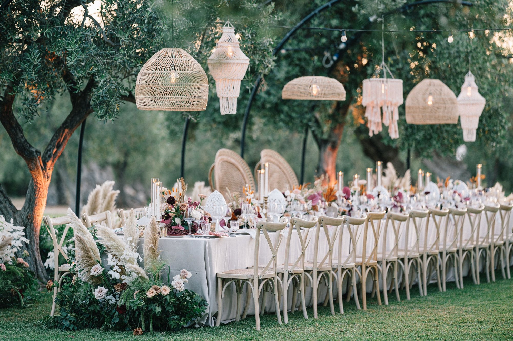Masseria Don Luigi, Fasano: a long table under the olive trees, with woven lanterns hanging above, candles and pampas grass