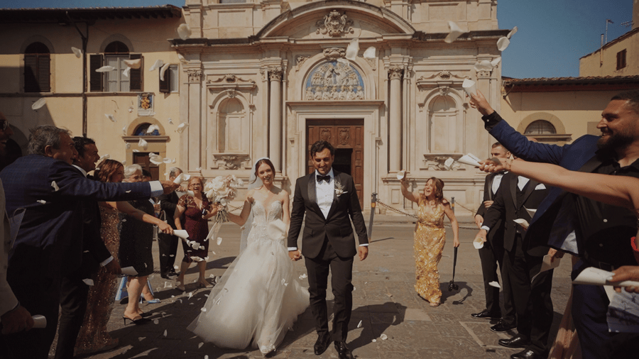 Storytelling Films — a couple walking out of a church into a shower of paper petals, guests cheering on both sides