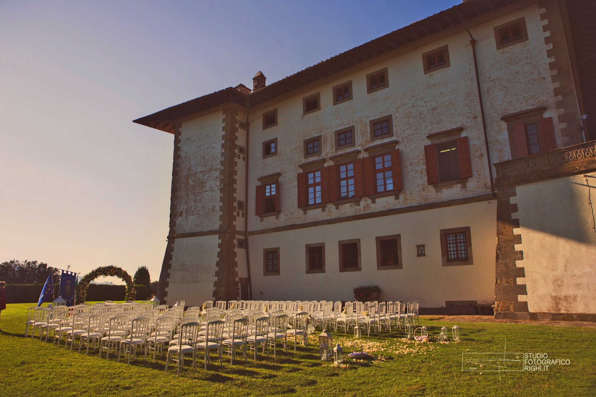 Tenuta di Artimino, Carmignano: rows of white chairs on the lawn before Villa Medicea La Ferdinanda at sunset
