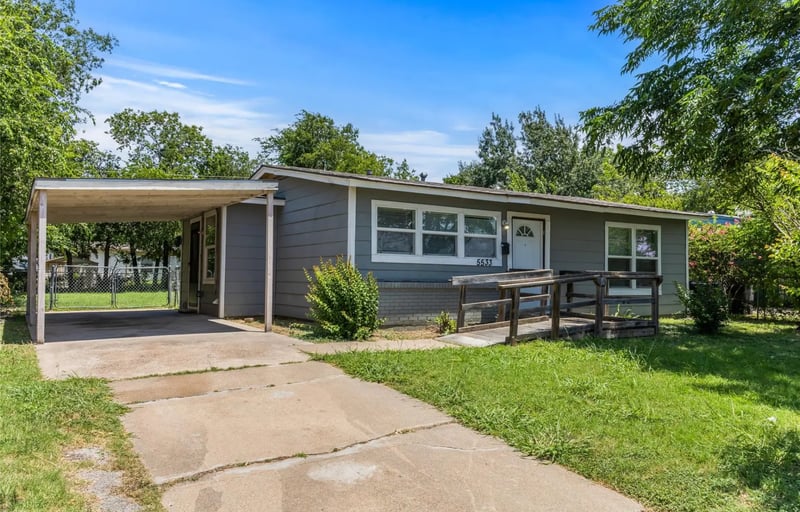 Single-story grey clapboard home with an attached carport and a wide concrete driveway in east Fort Worth, Texas