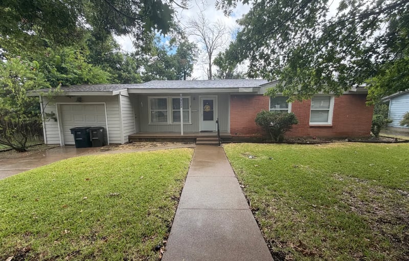 Single-story red brick and white siding home with a single-car garage and a long front walkway in southwest Fort Worth, Texas