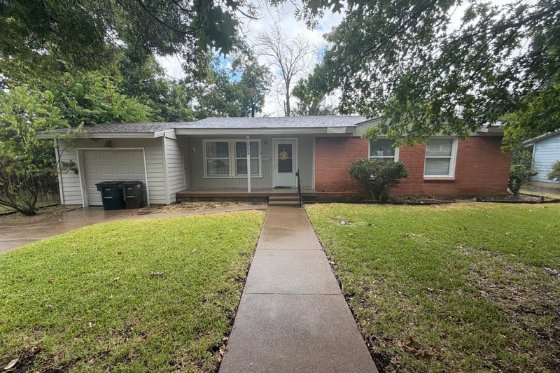 Single-story red brick and white siding home with a single-car garage and a long front walkway in southwest Fort Worth, Texas