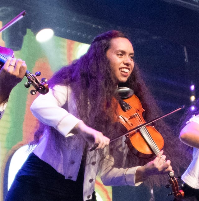 Natalia Dutton smiling as she plays the violin
