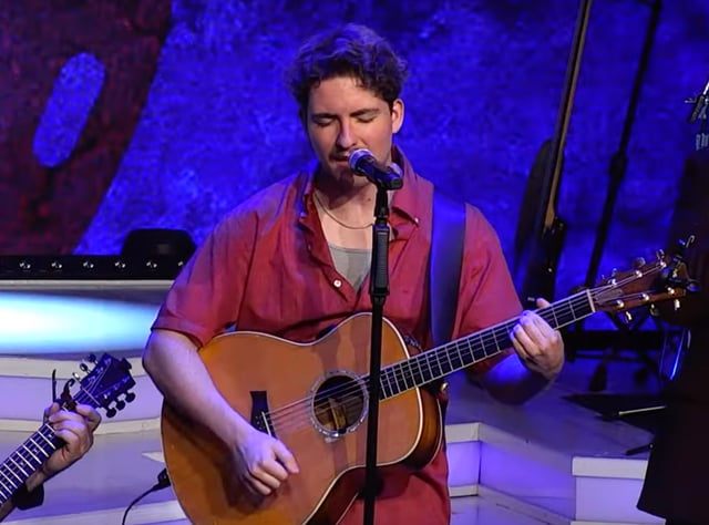 Josh (JD) Dutton singing and playing acoustic guitar