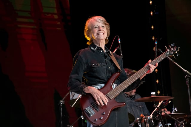 Sheila Dutton playing electric bass in a western shirt