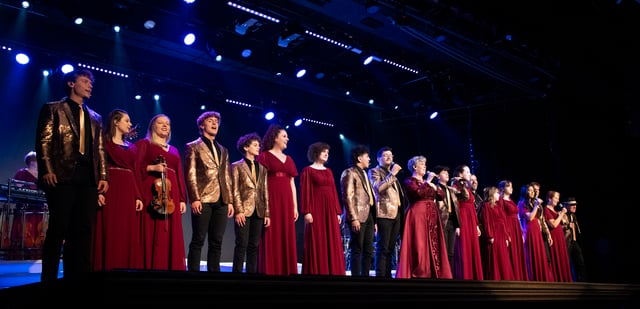 The whole Dutton family lined up across the stage in red gowns and gold jackets