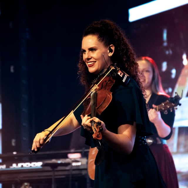 Abigail Dutton Wright smiling as she plays the violin