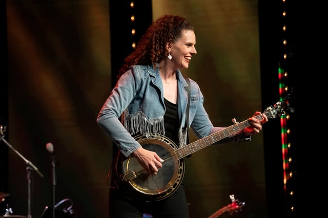 Abigail Dutton Wright playing banjo in a fringed denim jacket