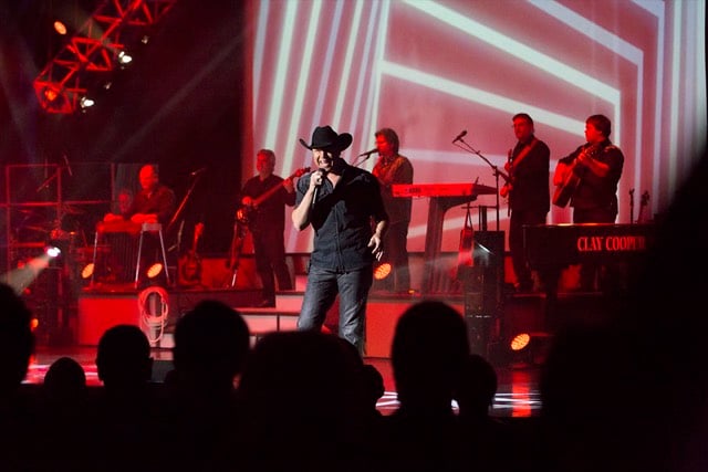 Clay Cooper on stage in a cowboy hat with his band