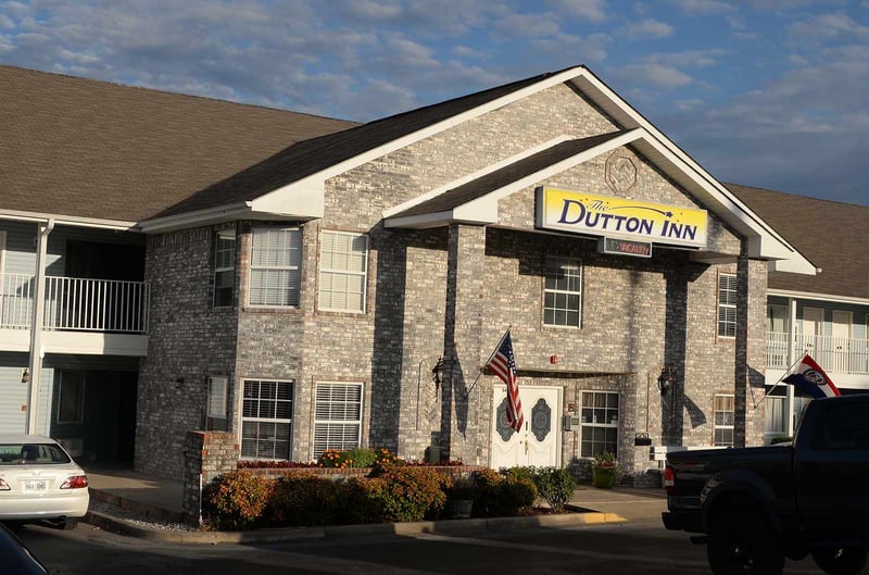 The Dutton Inn's brick entrance with its sign and flags