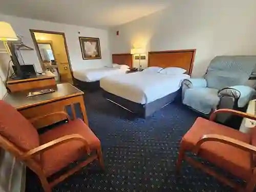 Double Queen room with armchairs and a desk
