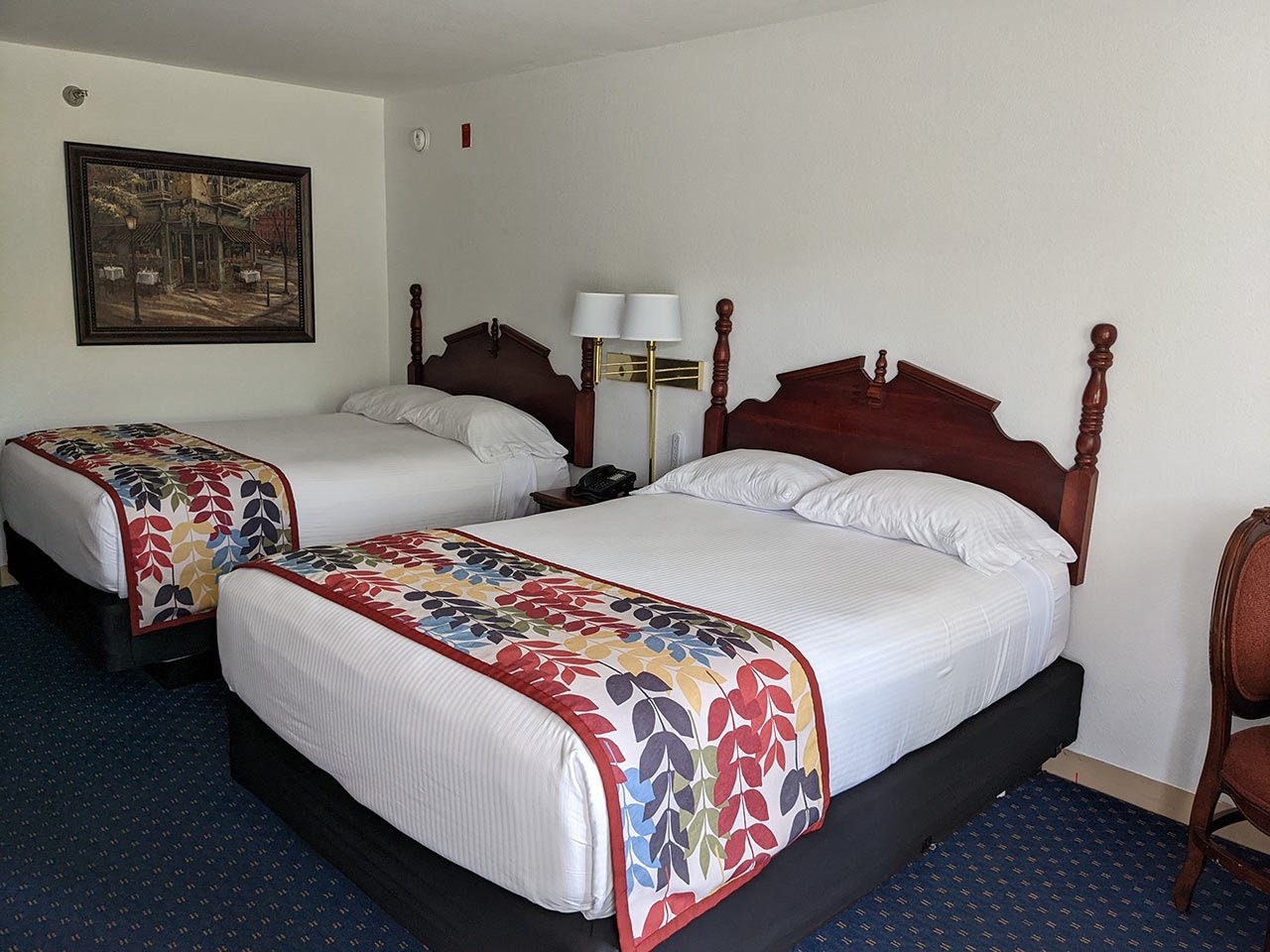 Double Queen room with two queen beds, carved headboards and patterned runners